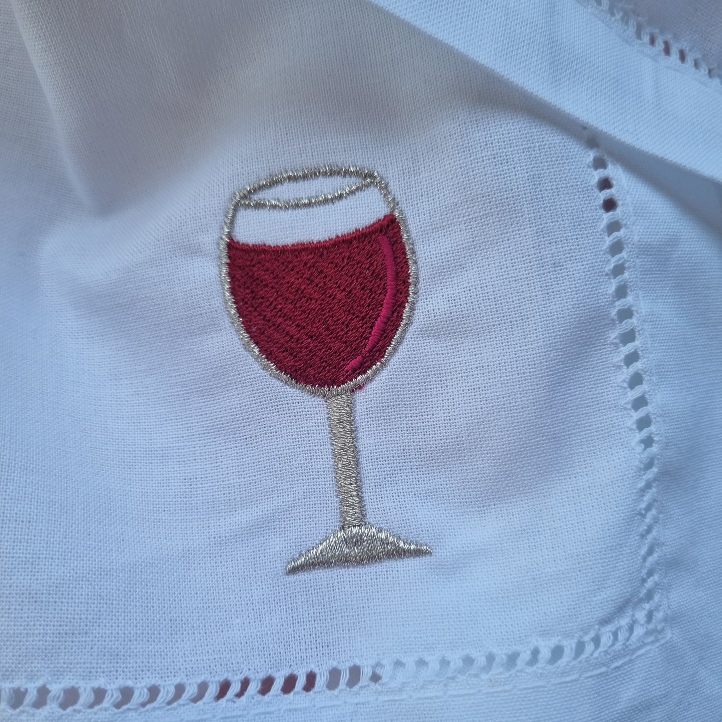 White cotton napkin with embroidered wine glass design