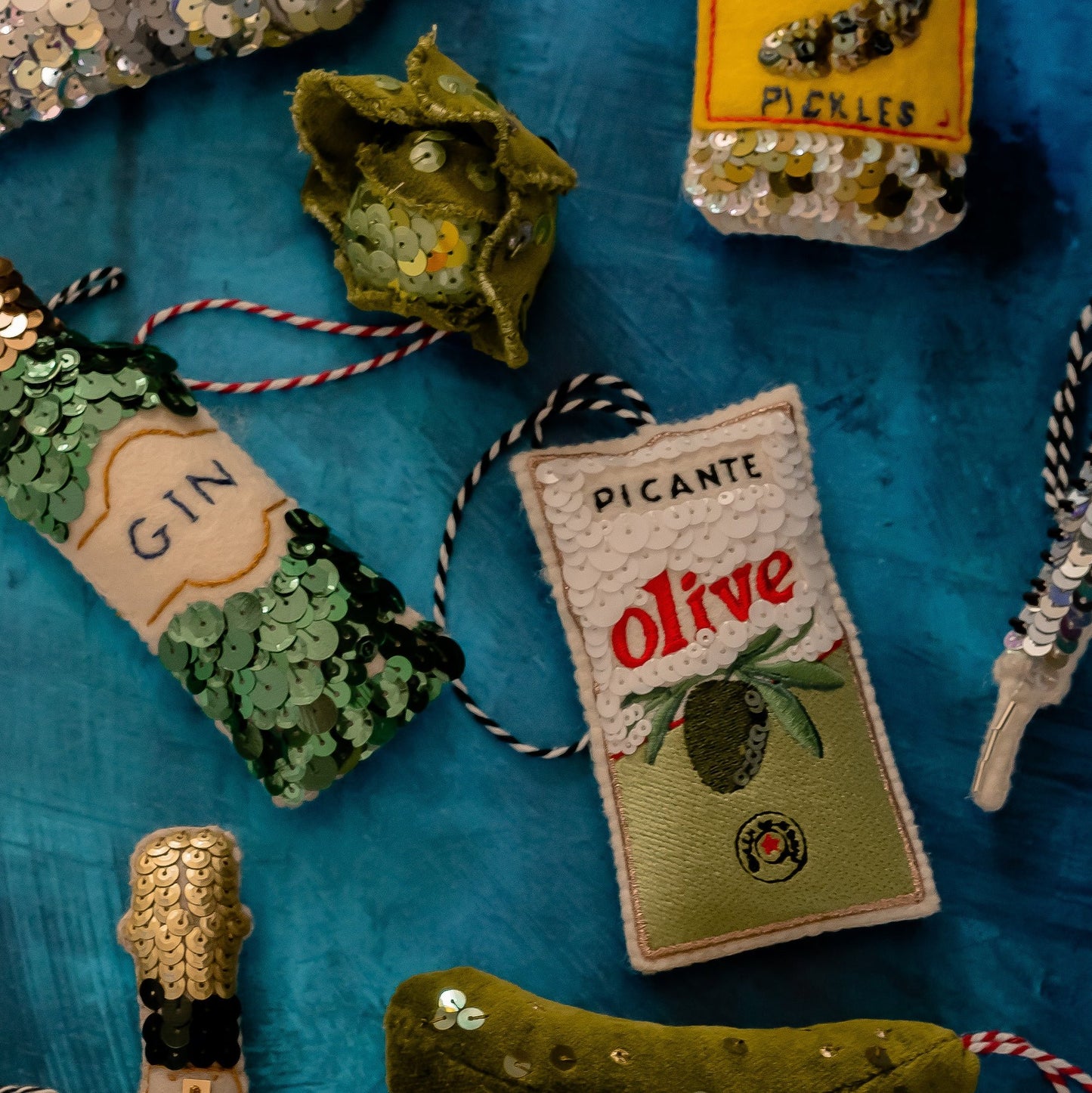 A collection of green sequinned ornaments on a blue background