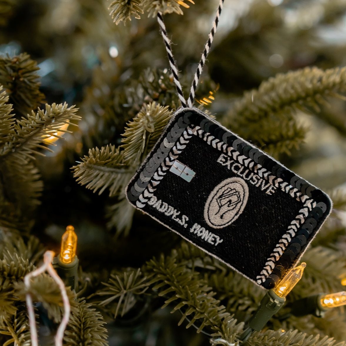 A black Credit card embroidered and sequinned ornament on a Christmas Tree