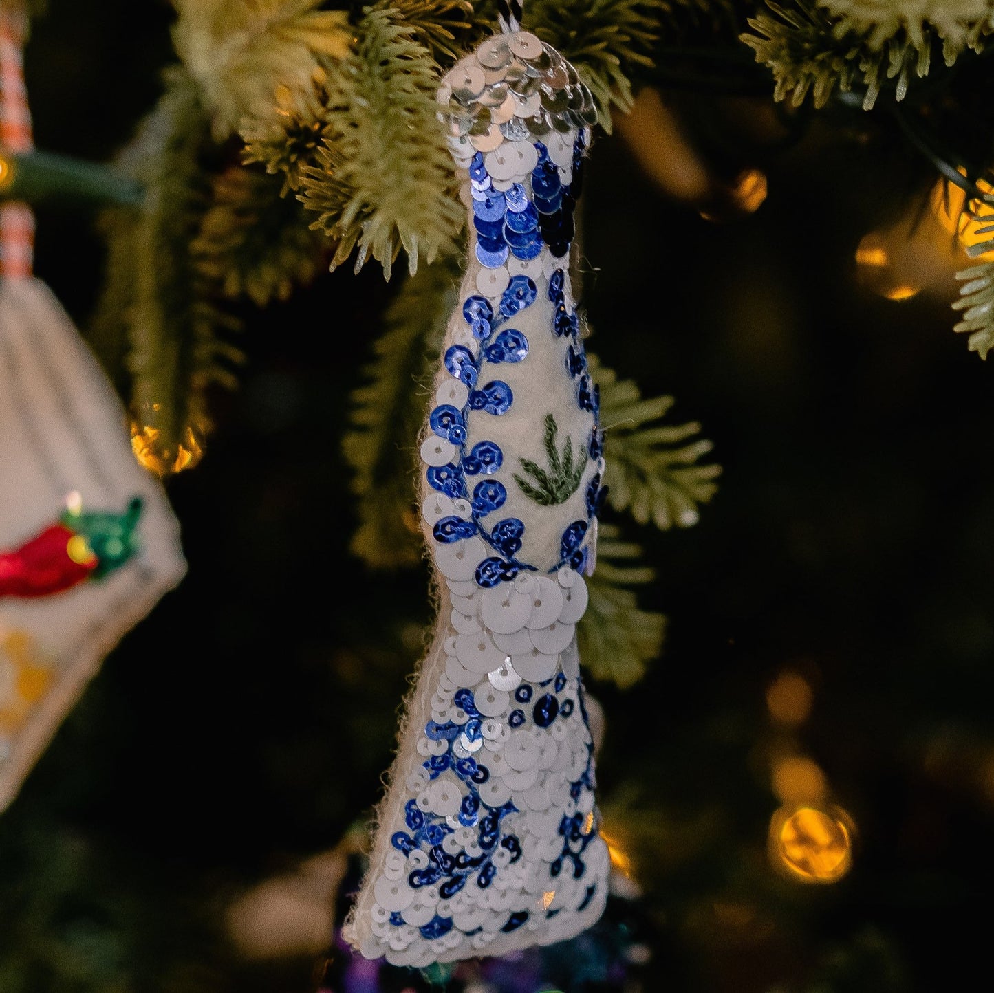A blue and white sequinned ornament tequila on a Christmas tree