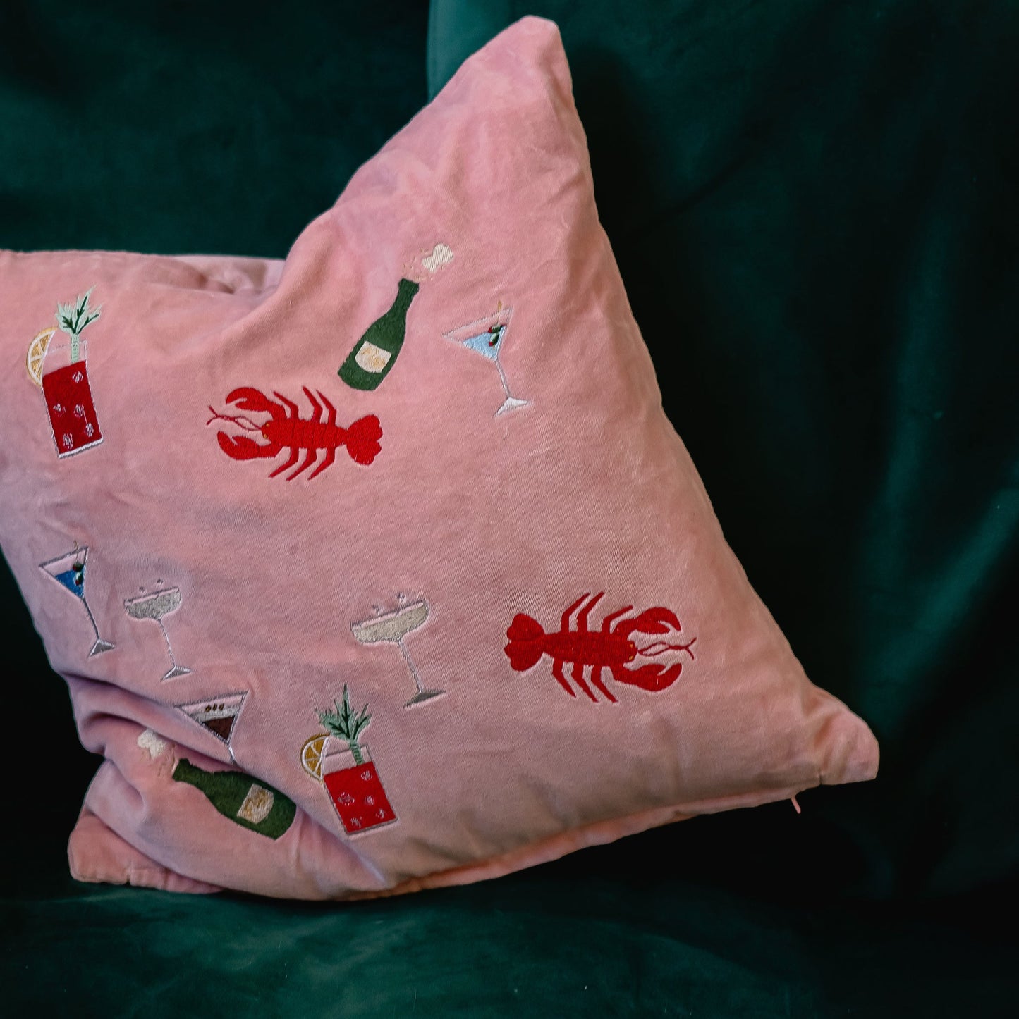 Pink velvet doodle cushion with embroidered lobsters, cocktails and champagne