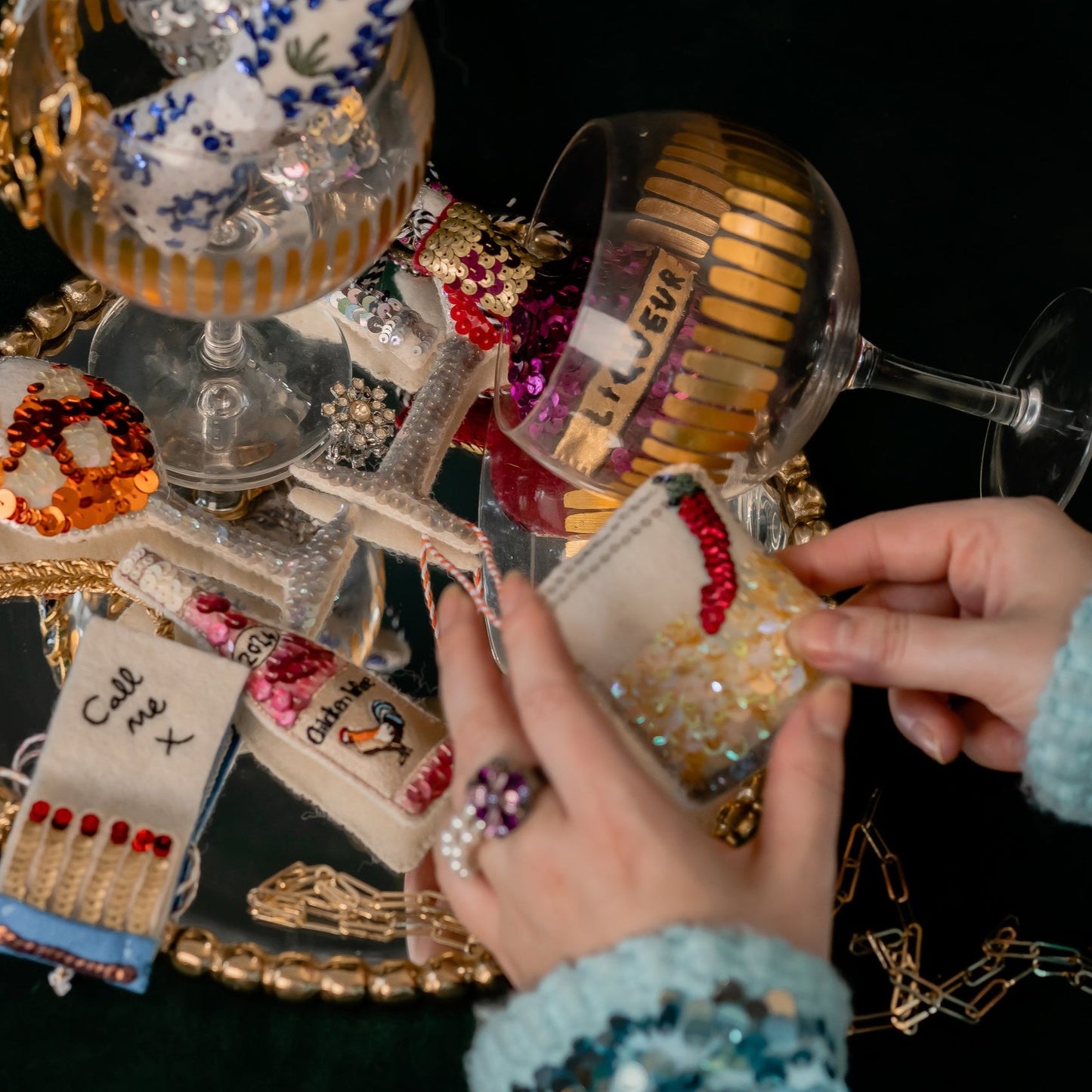 A collection of sequinned ornaments with a woman holding a spicy margarita ornament
