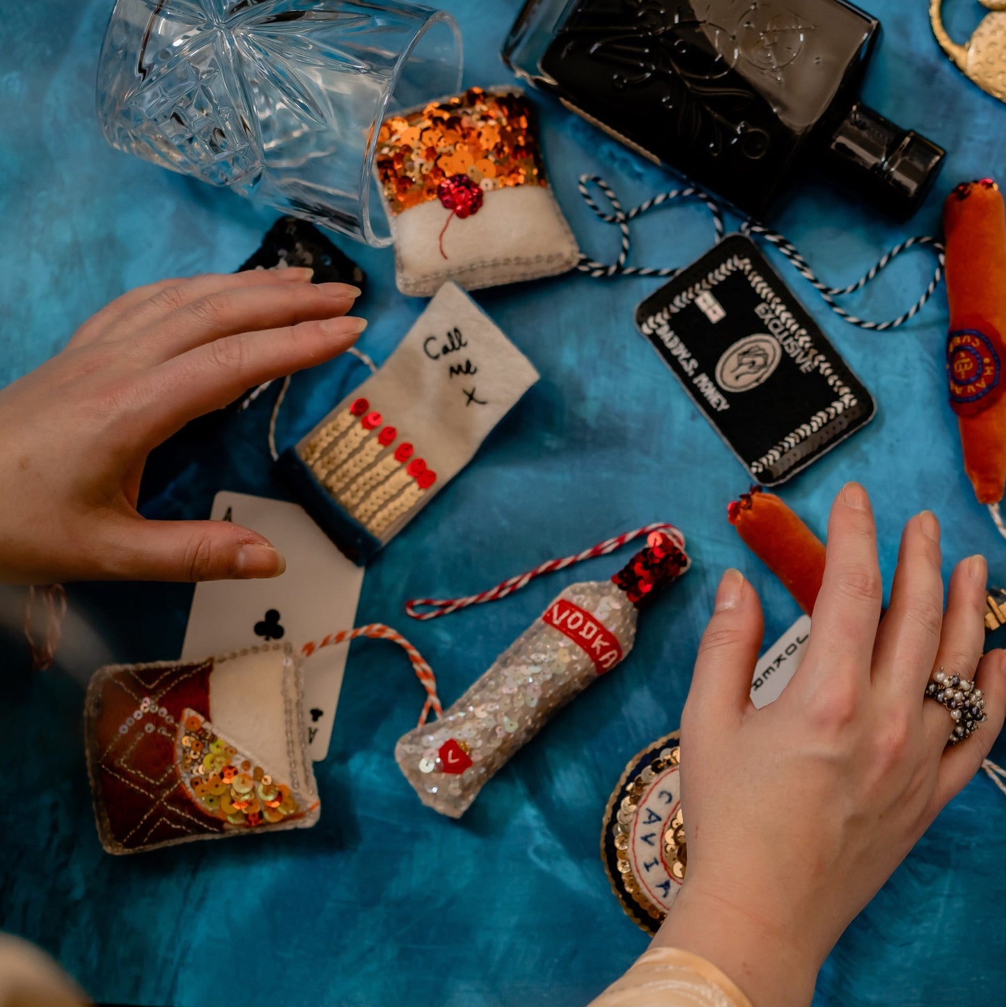 A collection of ornaments including an open matchbook embroidered ornament