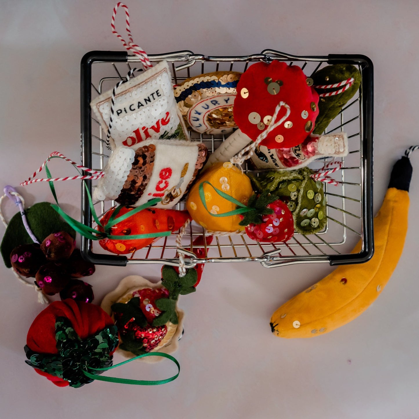A selection of sequinned groceries for the christmas tree in a shopping basket