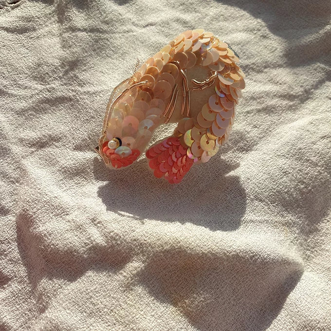 A pale pink prawn sequin hair clip