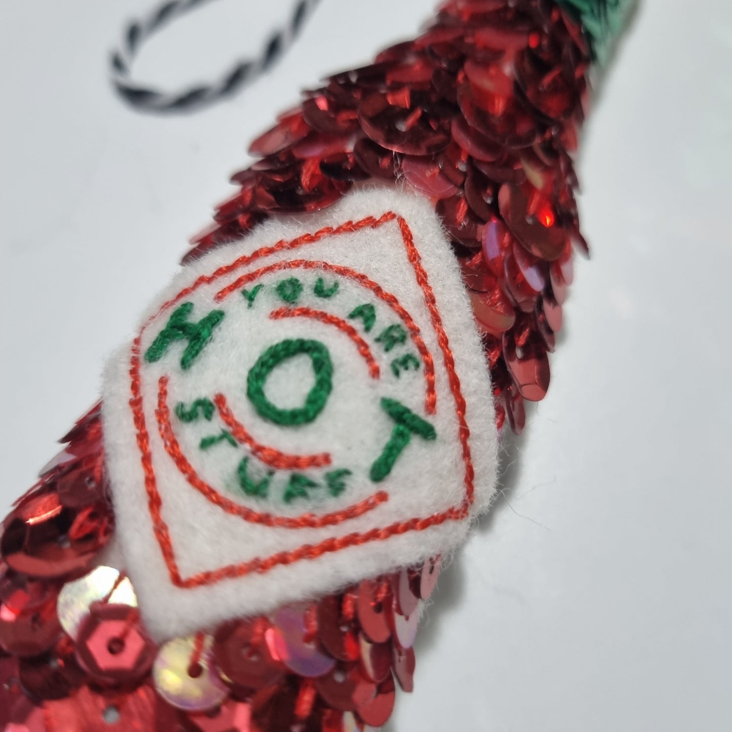 a sequinned tabasco bottle with a label saying you are hot stuff