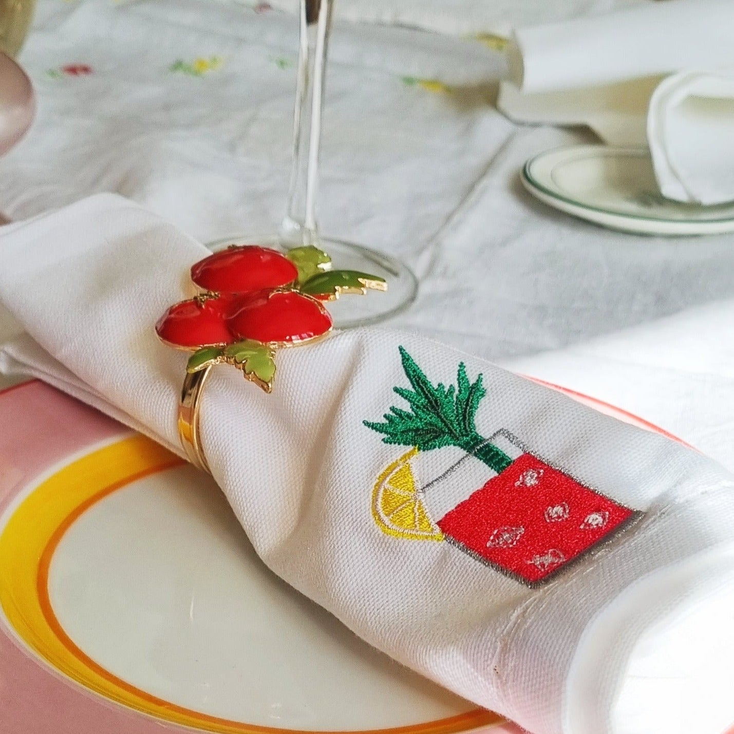 A tablescape with a white napkin with a bloody mary motif on it