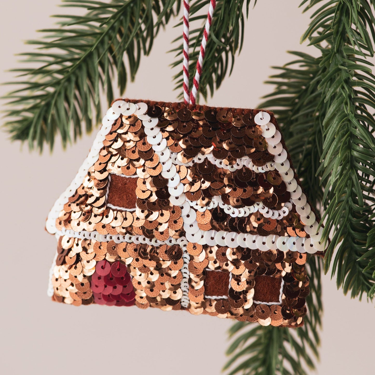 A sequinned gingerbread house ornament