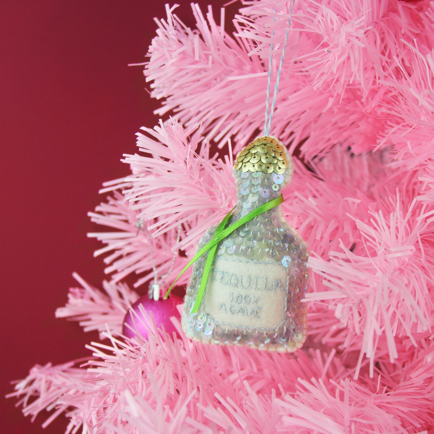 Tequila Hanging Decoration hanging on a pink 