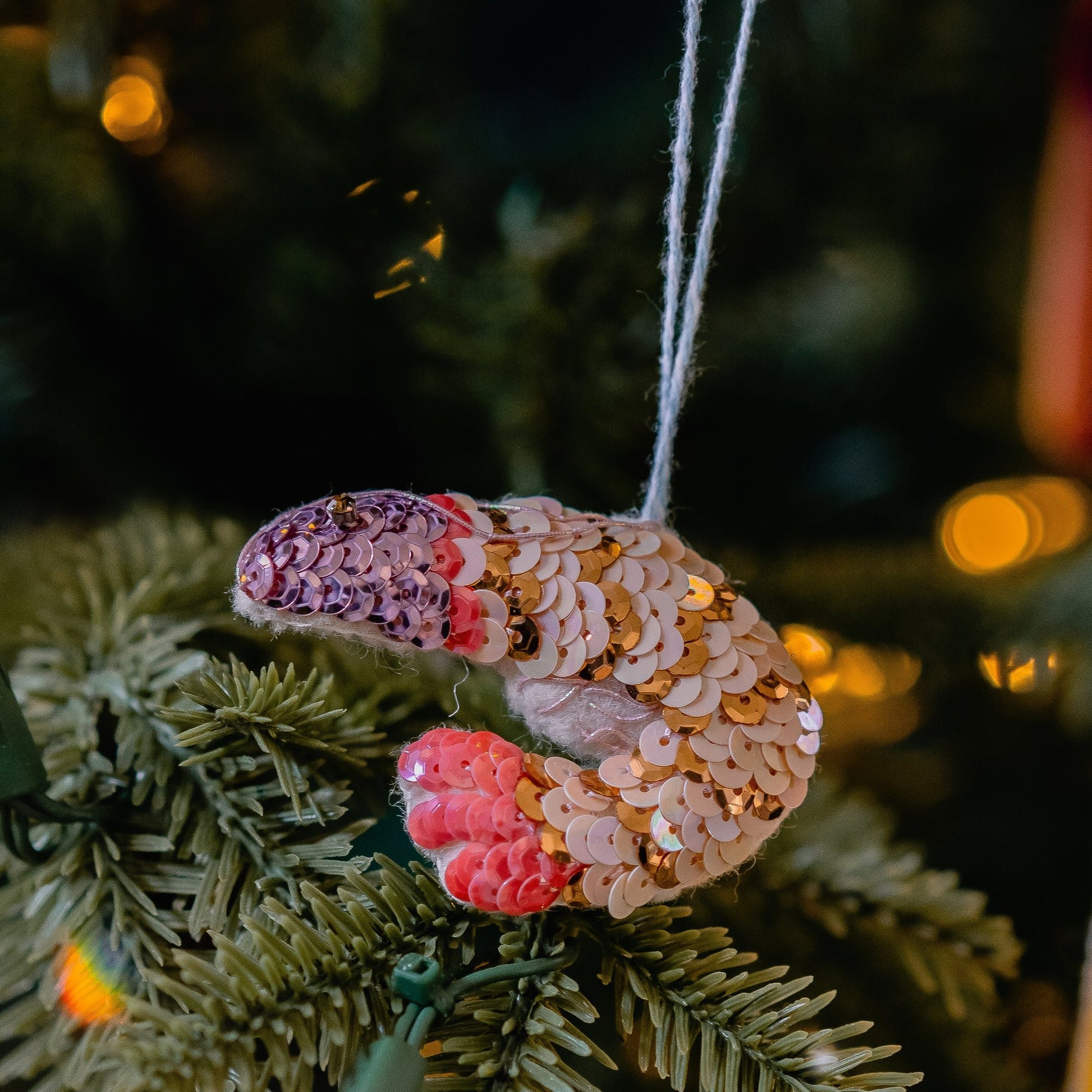 A sequinned prawn ornament on a green tree