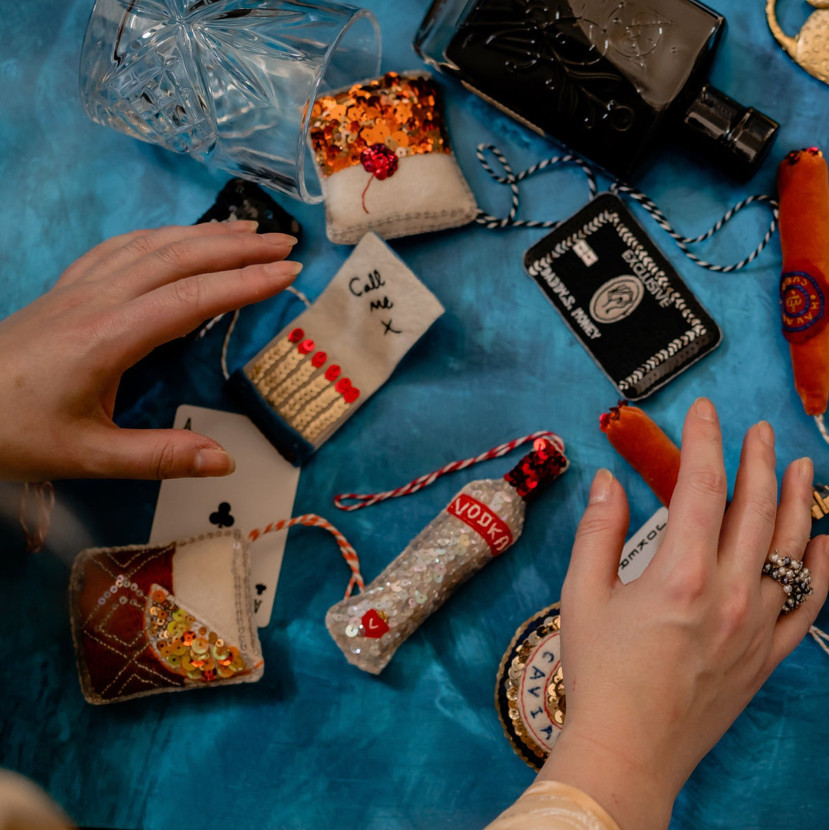 A collection of ornaments including an open matchbook embroidered ornament