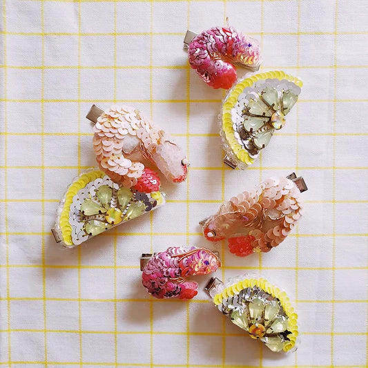 a collection of sequin prawn and lemon hair clips