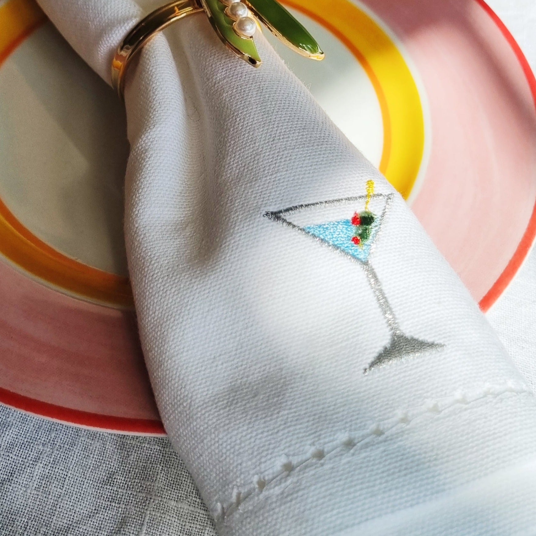 a white napkin with a classic martini motif embroidered on it