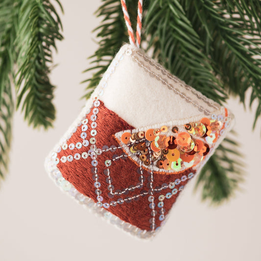  Negroni Sequin Ornament, a sequin and embroidered ornament hanging from a tree branch
