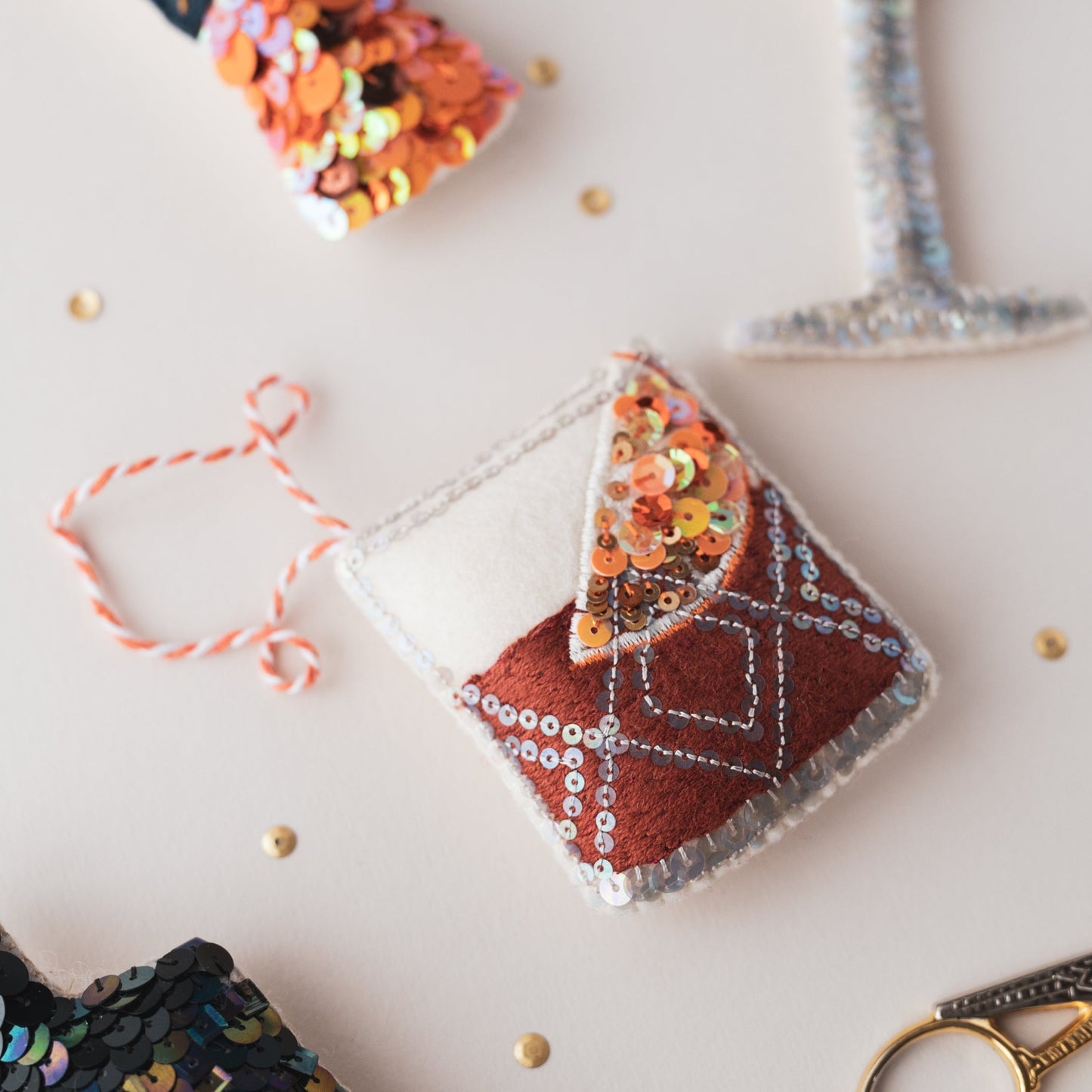 a sequin negroni ornament surrounded by other ornaments that you get small glimpses of
