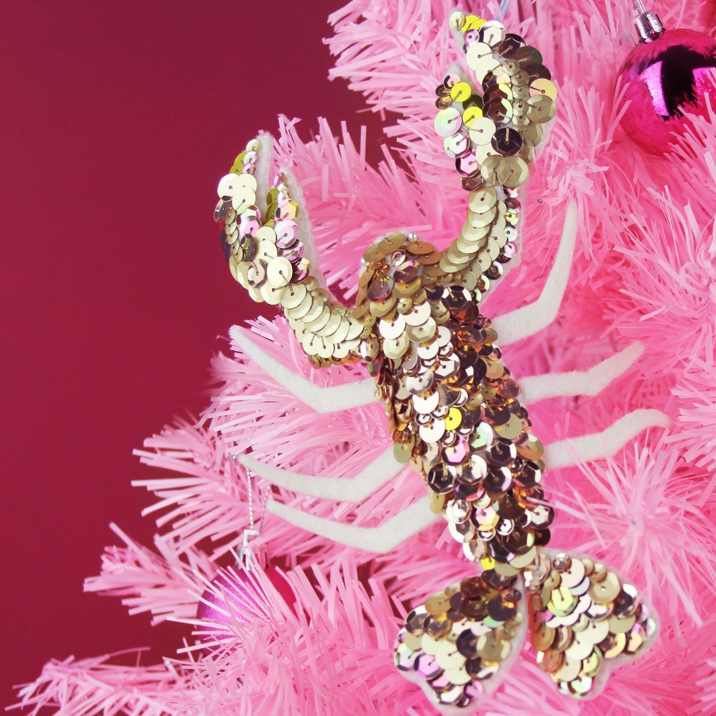 Gold Lobster Sequin Decoration on a pink tree