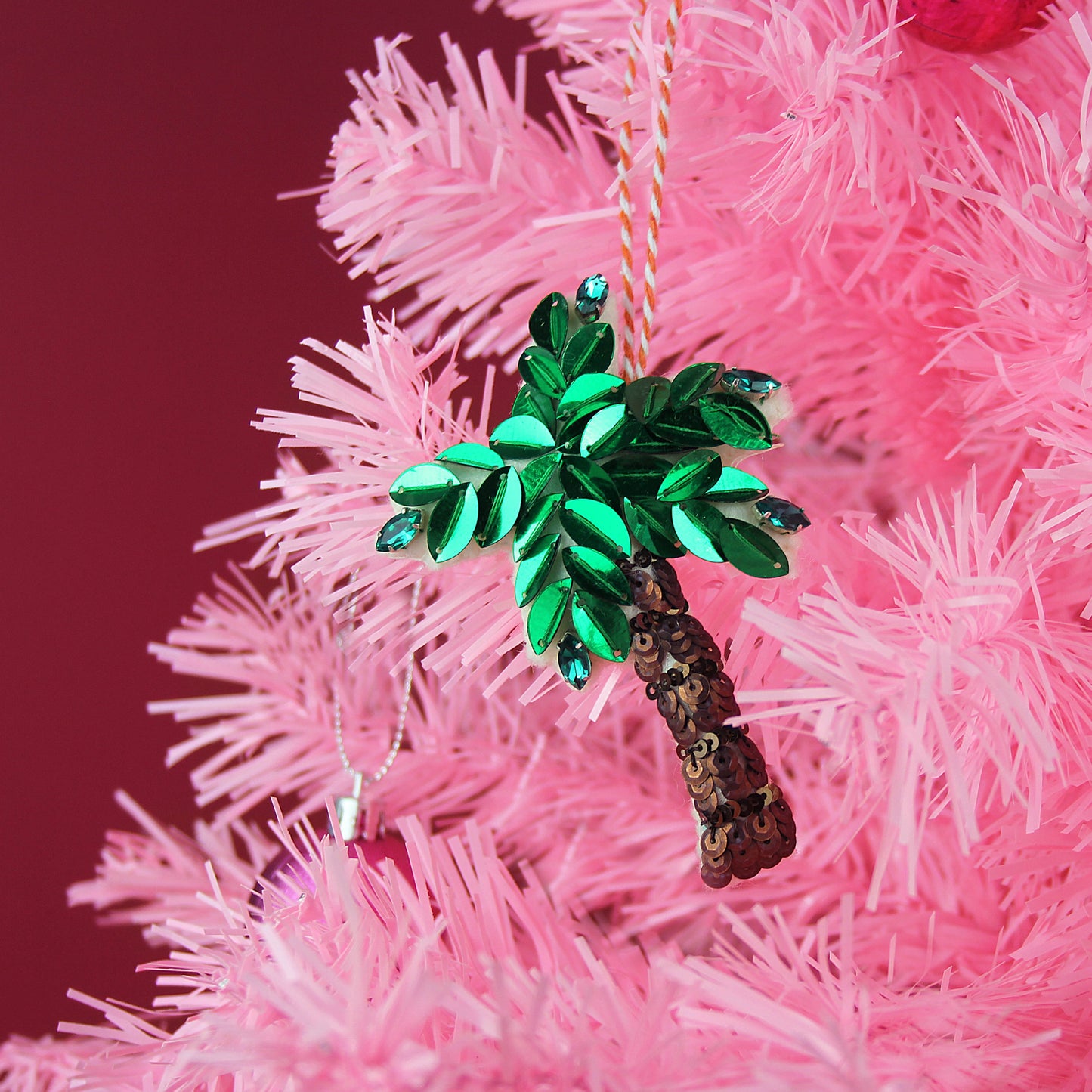 A sequin palm tree on a pink Christmas tree