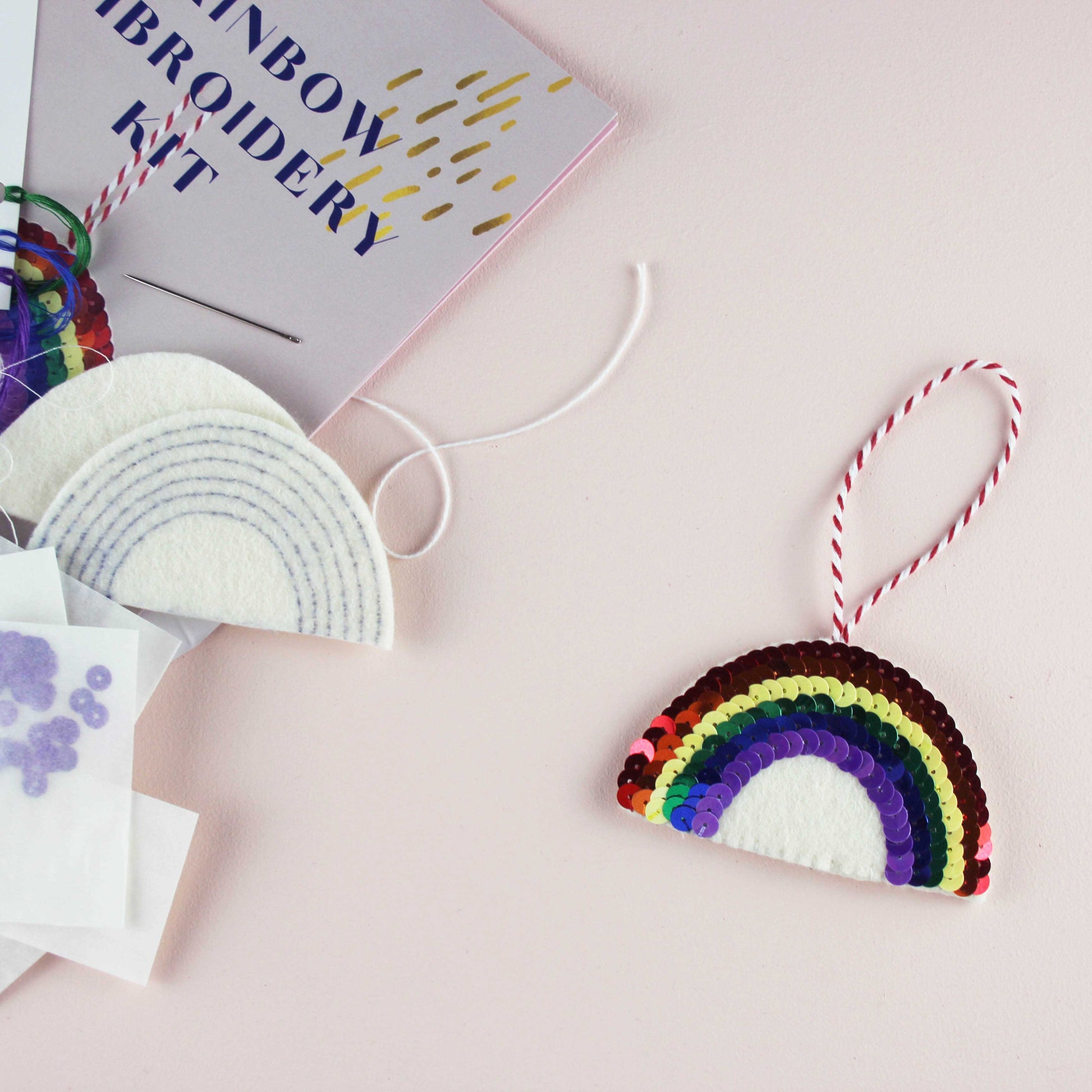 Rainbow Sequin DIY Ornament Kit, a sequin rainbow ornament with the inside of the kit laid out on the side